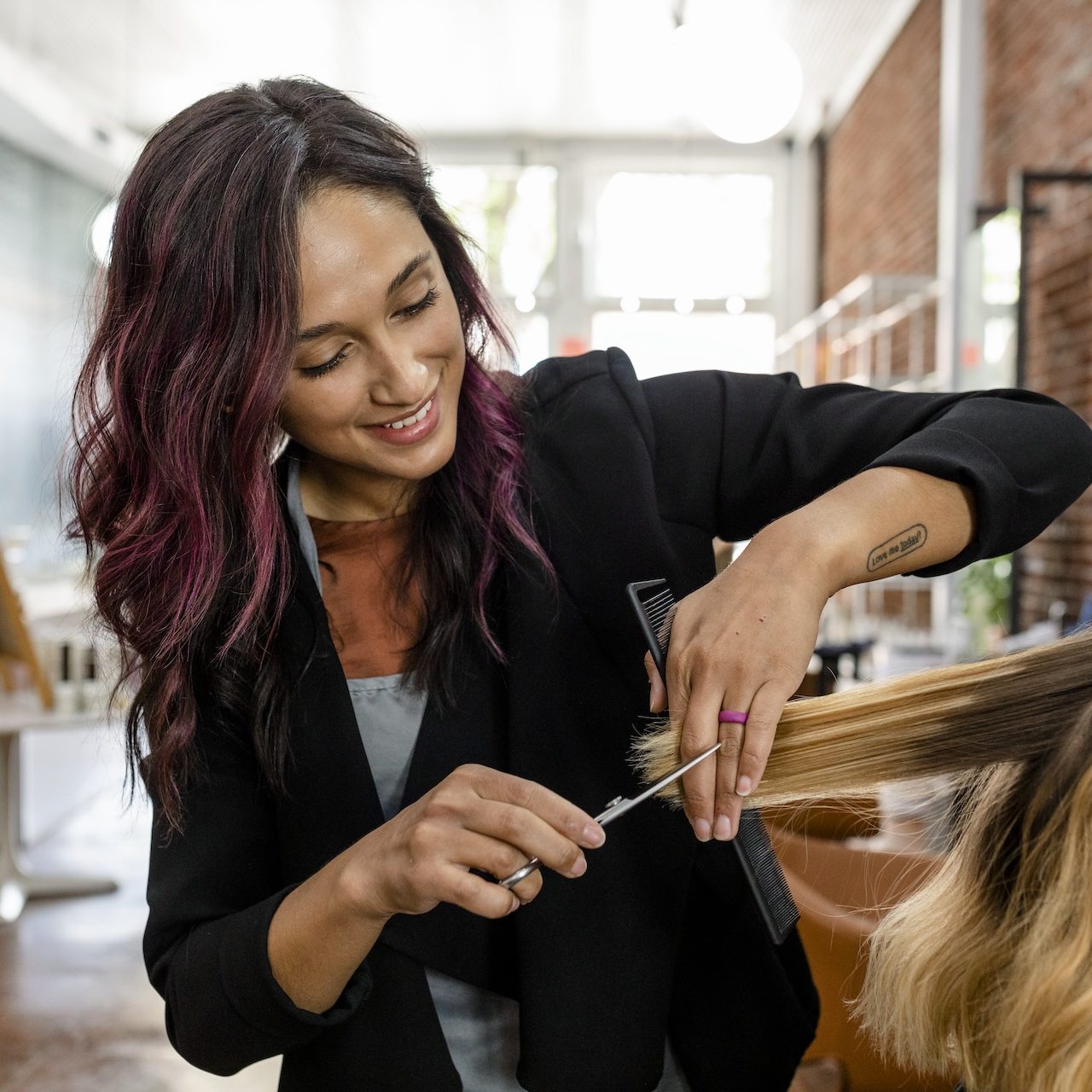 Hairstylist trimming hair of the customer in a beauty salon