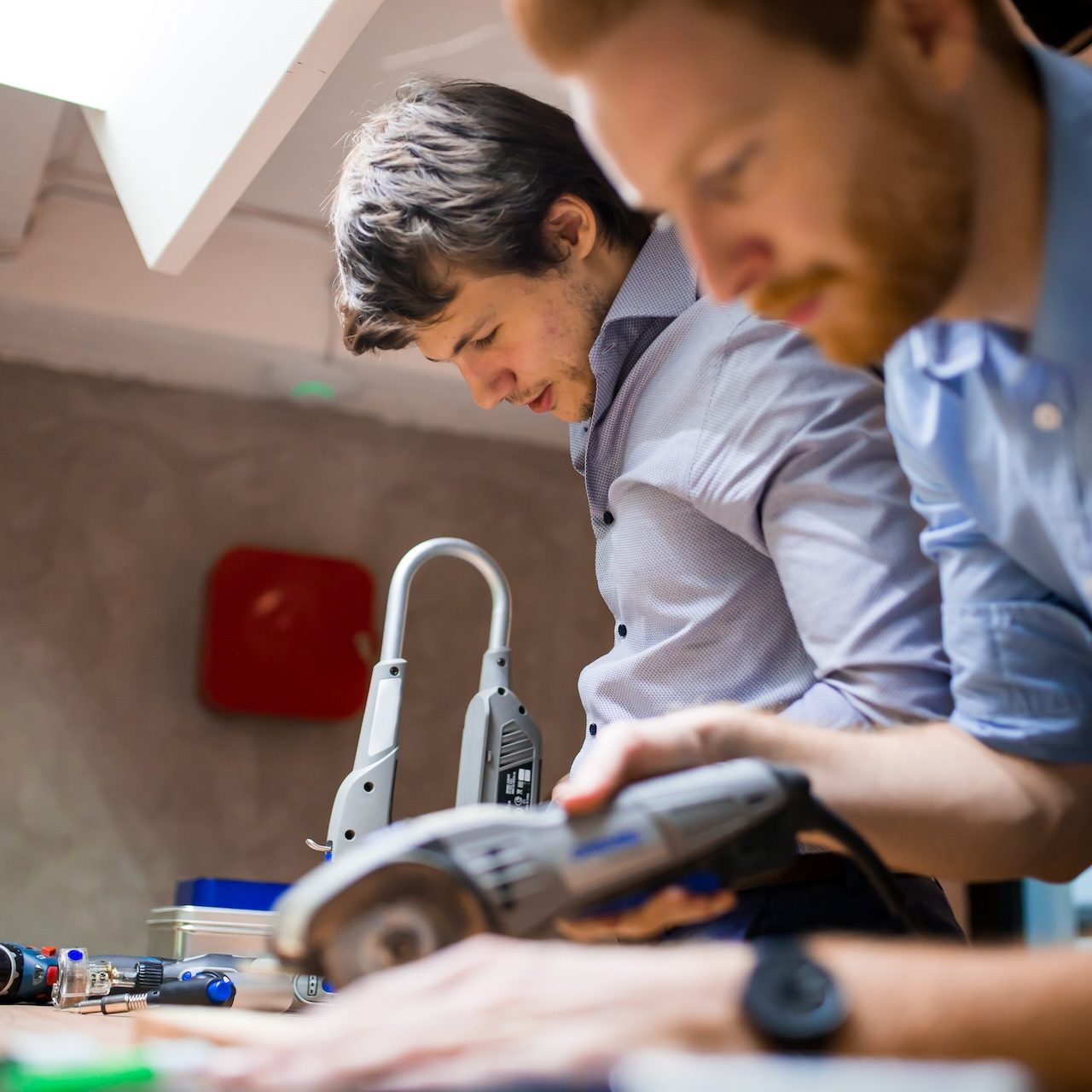 Two designers working together in workshop with precision tools